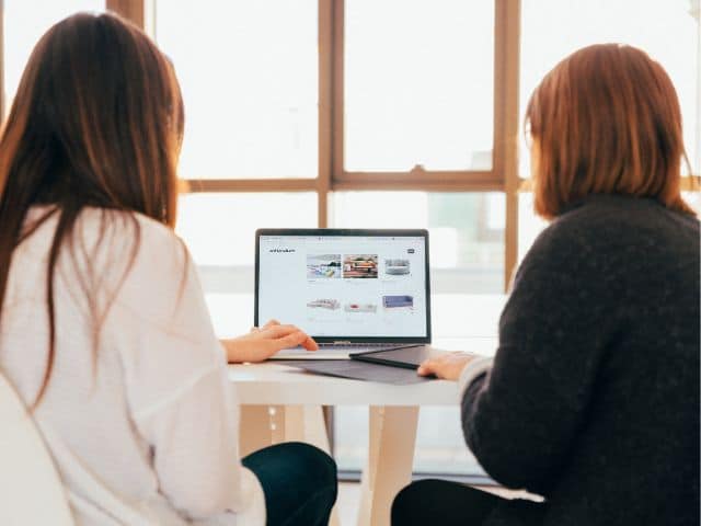 Image de deux femmes de dos qui sont devant un ordinateur, pour montrer les ateliers numériques de Giroussens